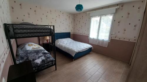 - une petite chambre avec des lits superposés et une fenêtre dans l'établissement Chez Denis, maison à la campagne, à Poilley