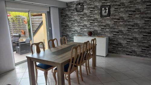 une salle à manger avec une table et des chaises en bois dans l'établissement Chez Denis, maison à la campagne, à Poilley