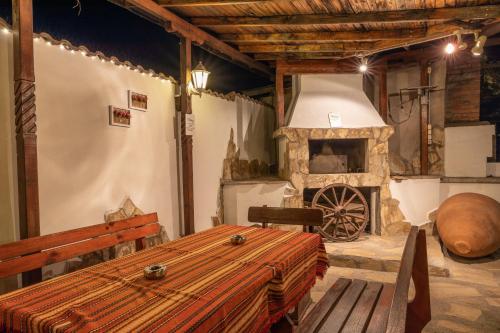 ein Raum mit einem Holztisch und einem Steinofen in der Unterkunft Hotel Kibor in Gŭlŭbovo