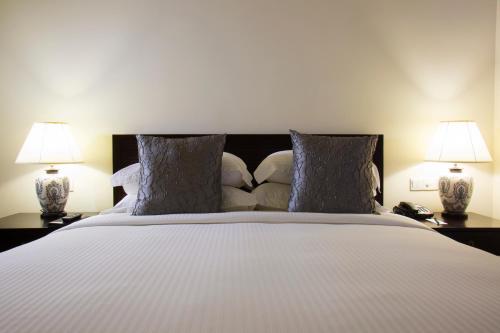a bedroom with a large white bed with two lamps at Galle Face Hotel in Colombo
