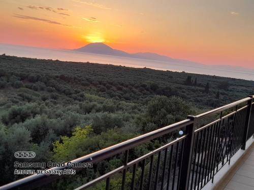 a sunset from a balcony with a mountain in the background at Elenas Villas in Kyllini