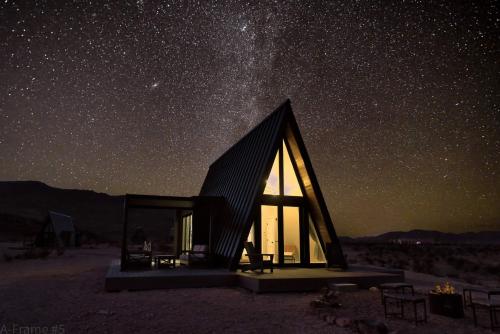 a wooden cabin under a starry sky at night at Stardust Big Bend Luxury A-Frame#5 great views in Terlingua