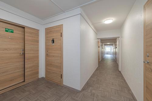 an empty hallway with wooden doors and a corridor at Pramonės Apartment #5 by PoloApartments in Kaunas