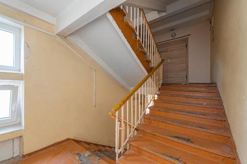 an empty room with a wooden staircase with a door at Pramonės Apartment #5 by PoloApartments in Kaunas