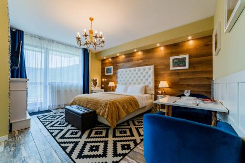 a hotel room with a bed and a chandelier at Romantic Jacuzzi Chic Apartment in Sinaia