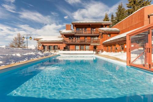 une grande piscine devant un immeuble dans l'établissement Résidence Digitale - 3 pièces pour 6 personnes - Piscine, sauna et Parking Privé, à Plagne 1800