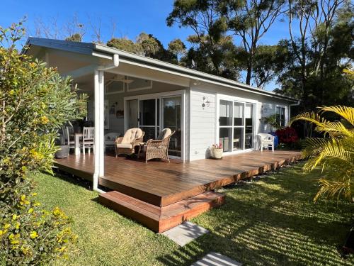 a house with a wooden deck in the yard at Palm Cottage Avalon Beach in Avalon