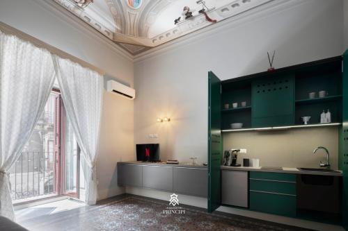 una cucina con armadi verdi e una grande finestra di Le Dimore dei Principi a Catania