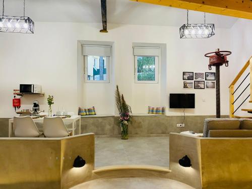 a living room with two chairs and a tv at Adega dos Moinhos in Pereiro