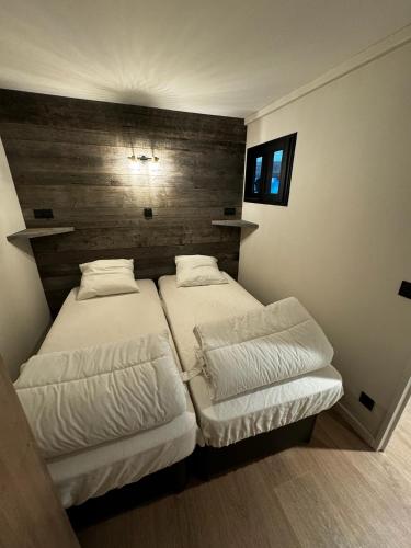 - une chambre avec 2 lits et une tête de lit en bois dans l'établissement Appartement T3 Pra Loup 1600, à Pra-Loup