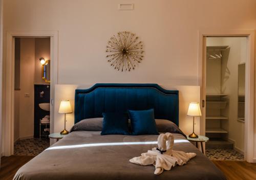 a bedroom with a large bed with a blue headboard at Rooms AL-Zabut in Sambuca di Sicilia