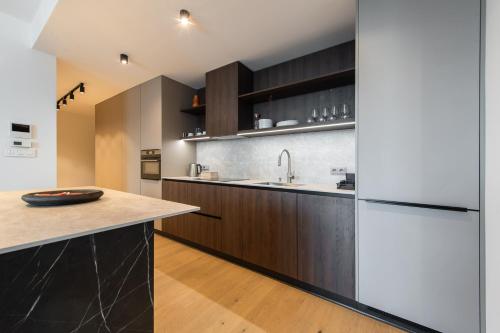 a kitchen with wooden cabinets and a white refrigerator at Nikas Eurovea Apartments - free parking in Bratislava