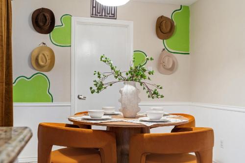 a dining room table with chairs and a vase with flowers at 4bd Near Airport & Downtown - Volleyball - Games in Irving