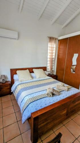 a bedroom with a wooden bed with towels on it at Villa MIA in Saint-François