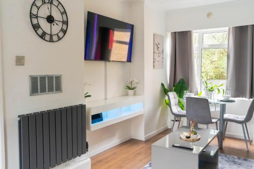 a living room with a table and a clock on the wall at Modern 1 bed apartment in Greenwich - WIFI - NETFLIX and stations nearby in London