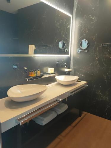 a bathroom with two sinks and a large mirror at Villa Szyprów in Jastarnia