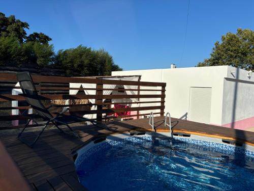 a deck with a chair next to a swimming pool at Herdade Palma T1p in Moita