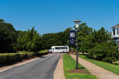 a bus is driving down a road with a street light at CCHK70 Peace of Paradise in Corolla