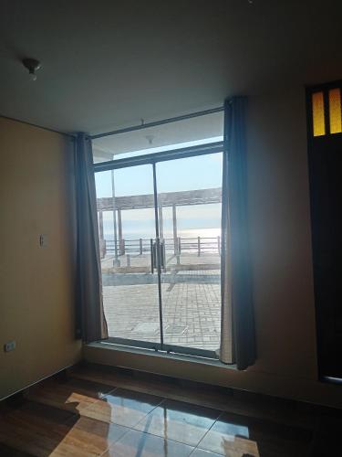 Una habitación con una gran ventana con vista al mar. en La Casa Del Hombre, en Puerto Chicama