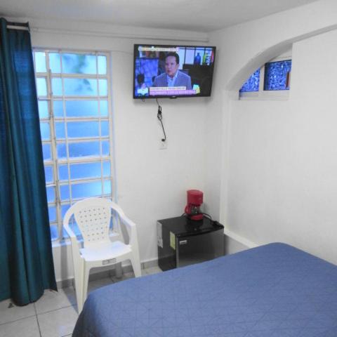 a bedroom with a bed and a tv on the wall at Cocos in Cancún