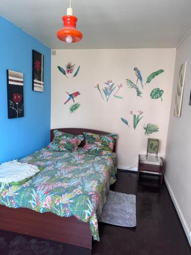 - une chambre avec un lit et un mur orné de plantes dans l'établissement Studio à louer, à Villard-Bonnot