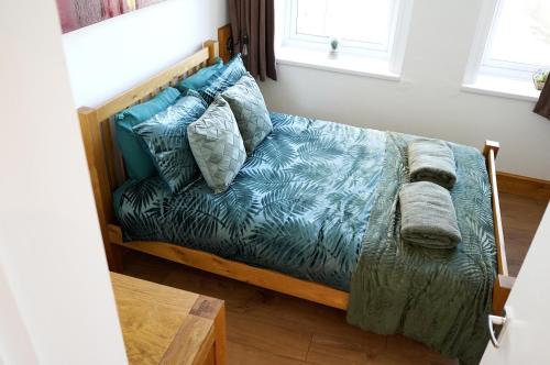 a bedroom with a bed with blue sheets and pillows at Church Street Studio Apartment in Keighley