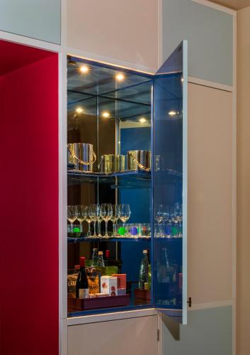 a glass cabinet with bottles and glasses in it at Hotel Saint Augustine in Houston