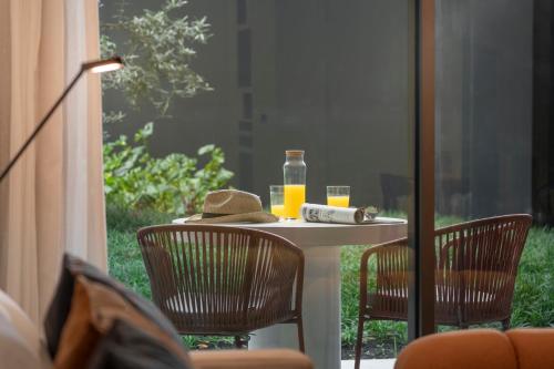 a table with two chairs and a bottle of orange juice at Luxury Garden Apartment at Savoy Insular in Funchal