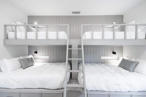two bunk beds in a small room with white at Brand New Catchlight House with Private Pool in Key West