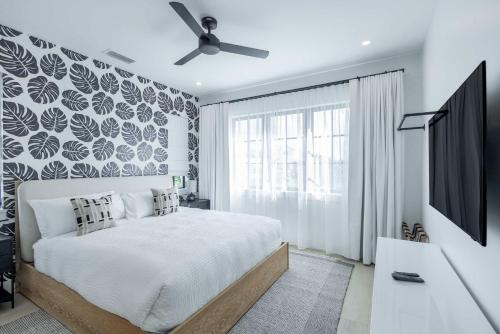 a bedroom with a bed and a ceiling fan at Brand New Catchlight House with Private Pool in Key West