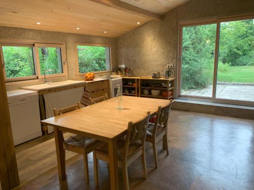 une grande cuisine avec une table et des chaises en bois dans l'établissement Chambre d'hôte, à Monflanquin