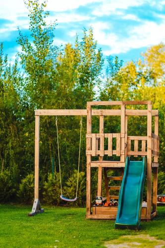 a playground with a slide and a swing at Home Stay Juniper in Jelgava