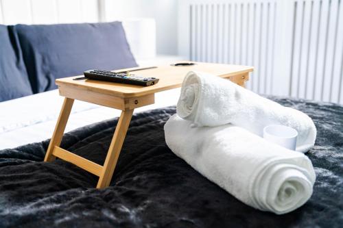 a table with a roll of toilet paper and a remote on a bed at Modern 1 bed apartment in Greenwich - WIFI - NETFLIX and stations nearby in London