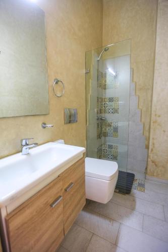 a bathroom with a sink and a shower and a toilet at Moon Surf in Imsouane