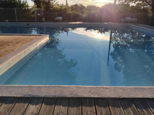 - une grande piscine avec une terrasse en bois dans la cour dans l'établissement MAISONNETTE pour DÉTENTE ou TRAVAIL, à Saint-Aubin-de-Nabirat