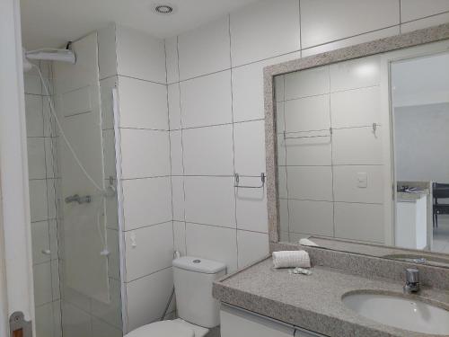 a bathroom with a toilet and a sink and a mirror at Marinas da Barra - Flat Beira-Mar em Barra de Jangada por Yolo in Recife
