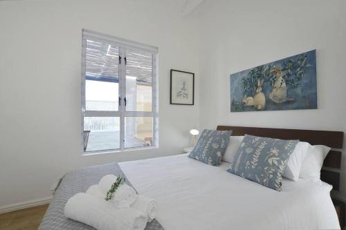 a bedroom with a bed with a teddy bear on it at Cozy Holiday Cottage - XX Cottage Yzerfontein in Yzerfontein