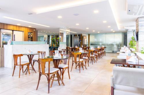 a restaurant with tables and chairs in a restaurant at Citi Hotel Express Caruaru in Caruaru