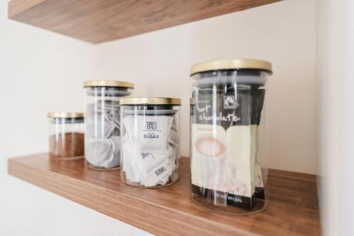 three jars sitting on a wooden shelf at Ely Stays Flat 1 in Ely