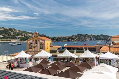 a market with white tents in front of a building at Superbe Duplex avec vue ! in Villefranche-sur-Mer