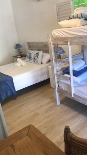 a bedroom with two bunk beds and a wooden floor at Santa Hospedaria Beach in Bertioga