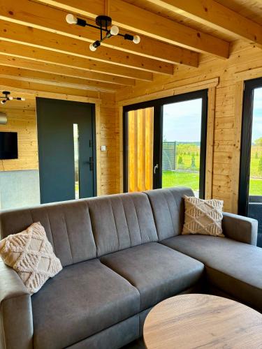 a living room with a couch and a table at Wodne Widoki - domek letniskowy z jacuzzi in Dziwnówek