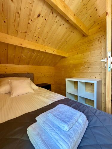 a bedroom with a bed in a wooden cabin at Wodne Widoki - domek letniskowy z jacuzzi in Dziwnówek