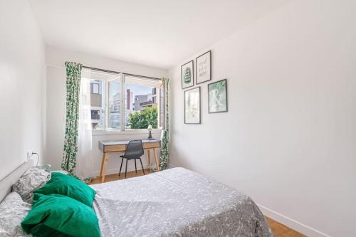 une chambre avec un lit, un bureau et une fenêtre dans l'établissement Appartement de Standing, à Saint-Denis