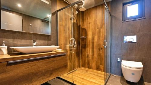 a bathroom with a sink and a toilet and a shower at Luxury Villa Close to Shops and Restaurants -Large Garden Pool Table and Table Tennis in Fethiye