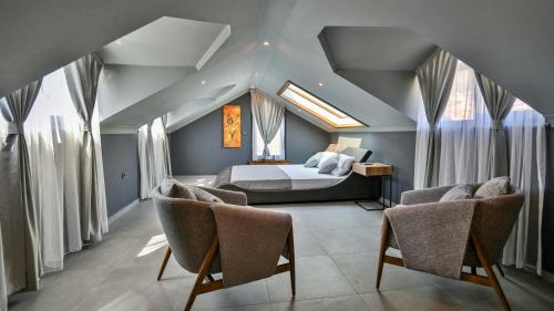 a bedroom with a bed and some windows and chairs at Luxury Villa Close to Shops and Restaurants -Large Garden Pool Table and Table Tennis in Fethiye