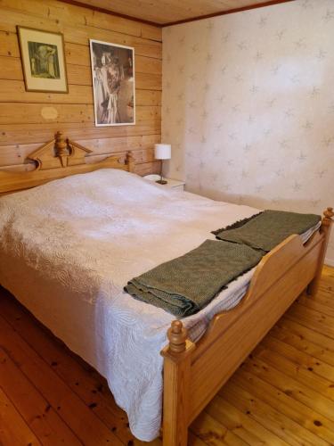 a bedroom with a large bed in a wooden room at Rolsmo Norregård 16 in Linneryd
