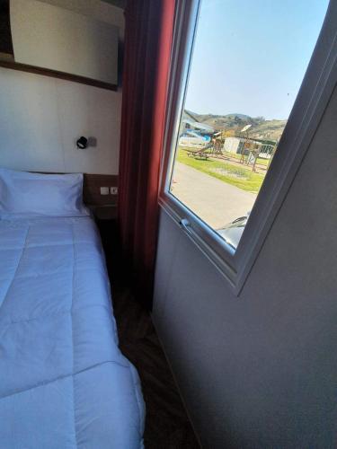 a small bedroom with a bed and a window at Les flots de Condrieu - VIA -RHÔNA -8 pers, et vue sur Rhône-BBQ in Condrieu