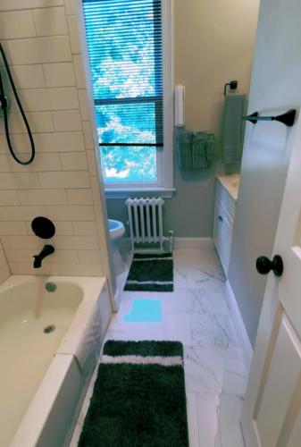 a bathroom with a bath tub and a window at Bloom Victorian Bed & Breakfast in South Orange