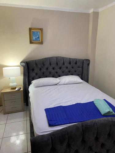 a bedroom with a large bed with a blue blanket at Suite full equipado, céntrico y con garage in Machala